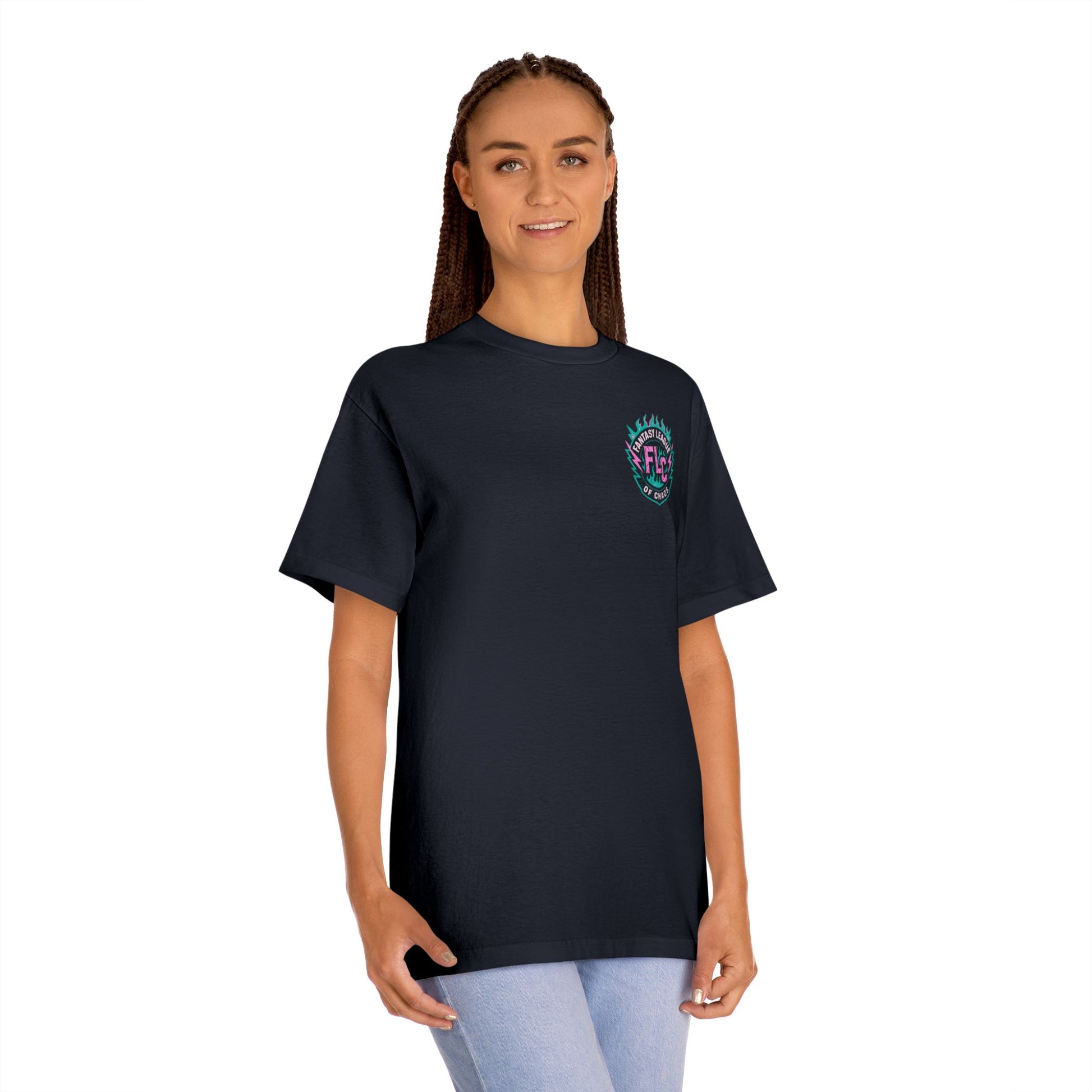 A woman with long braids wears the Printify Unisex Classic Tee featuring a small, colorful Dripball Design on the left chest, paired with light blue jeans, standing and smiling in front of a plain white background.