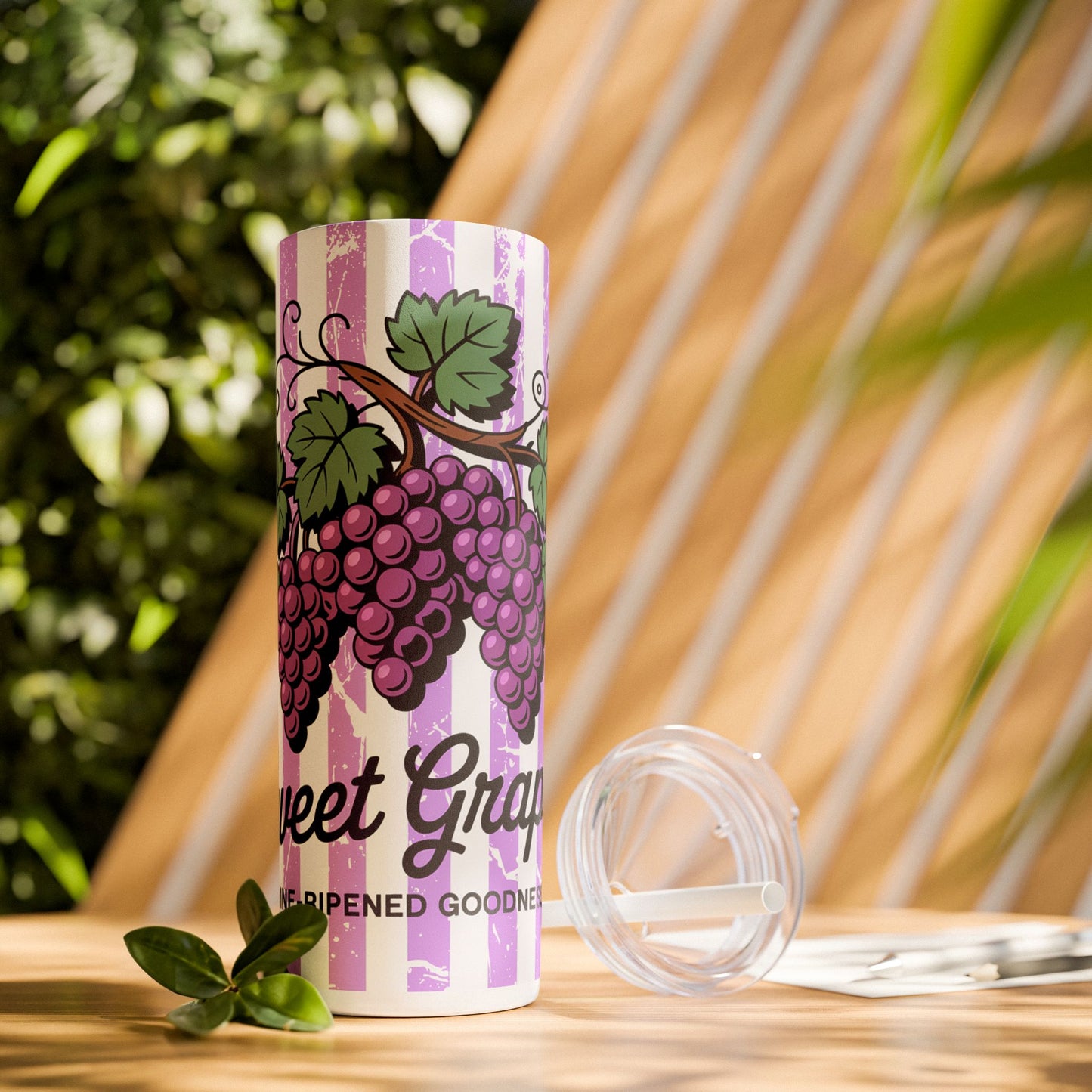 Sweet Grape Skinny Tumbler with Straw, 20oz stylishly placed on a table with a natural background, great for wine lovers and summer gatherings.